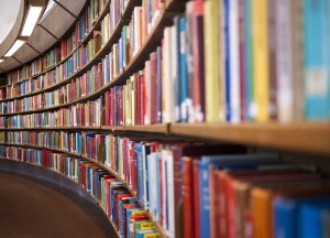 Bild på en bokhylla full med böcker, som kröker sig längs en lång korridor
