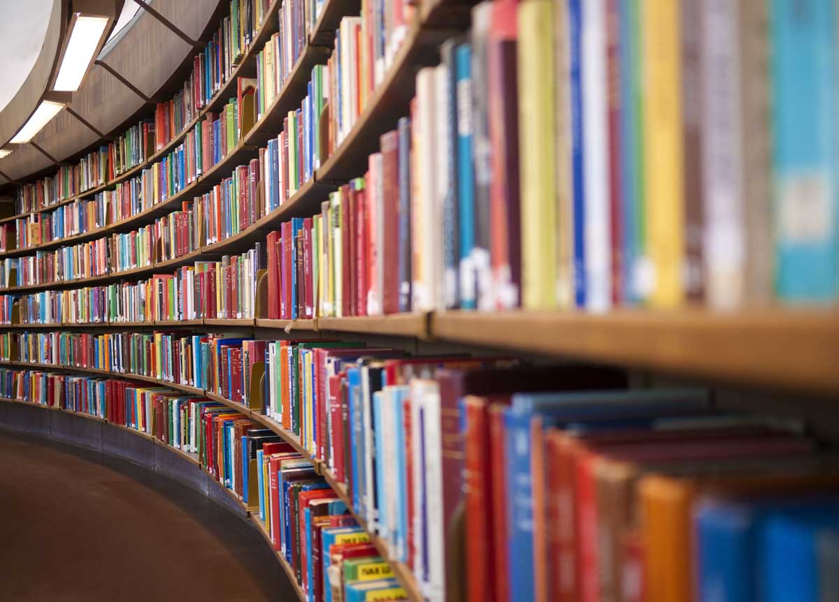 Bild på en bokhylla full med böcker, som kröker sig längs en lång korridor