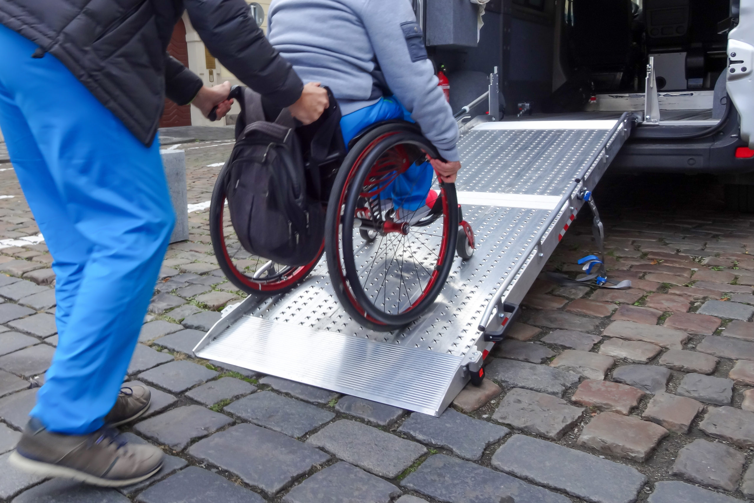 Rullstolsburen person på väg in i en bil med ramp. Foto: iStock