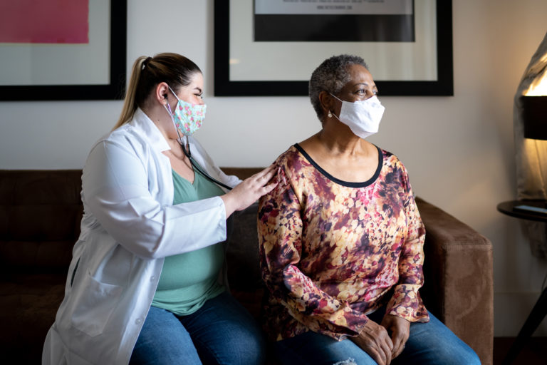 Kvinnlig läkare undersöker äldre kvinnliga patient med stetoskop. Foto: iStock