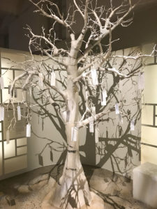 Fotografi på ett konstgjort träd med pappersetiketter som blad