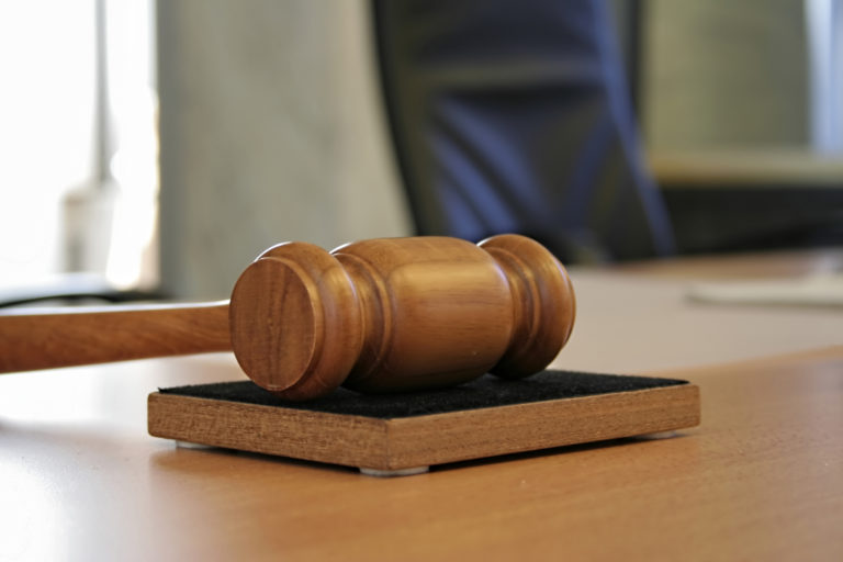 Närbild av klubban som ligger på ett bord, i en rättegångssal. Foto: iStock