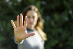 En kvinna håller upp sin hand i en gest som betyder nej eller stopp. Foto: iStock