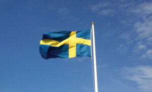 Bild på svenska flaggan mot en blå himmel. Bild från Wikimedia Commons