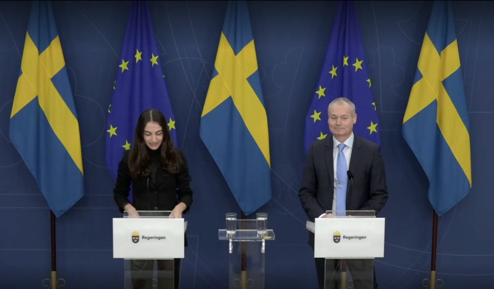 Bilden visar klimatminister Romina Pourmokhtari (L) och Johan Kuylenstierna, som ny GD för Naturvårdsverket, framför an fond av svenska flaggor och EU-flaggor.